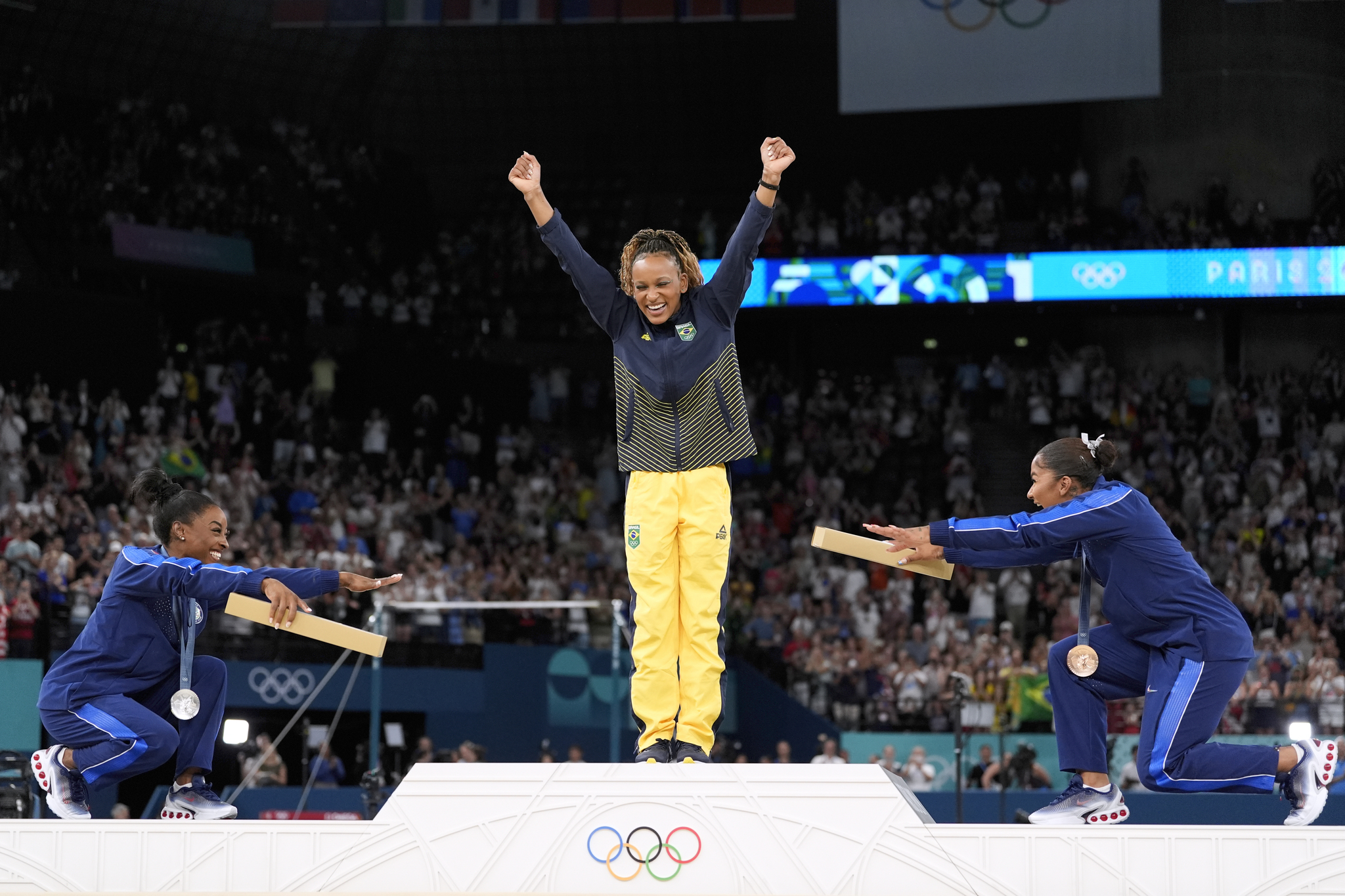 Silver medalist Simone Biles of the United States, left, and bronze medalist Jordan Chiles, of the United States, right, bow to gold medalist Rebeca Andrade, of Brazil