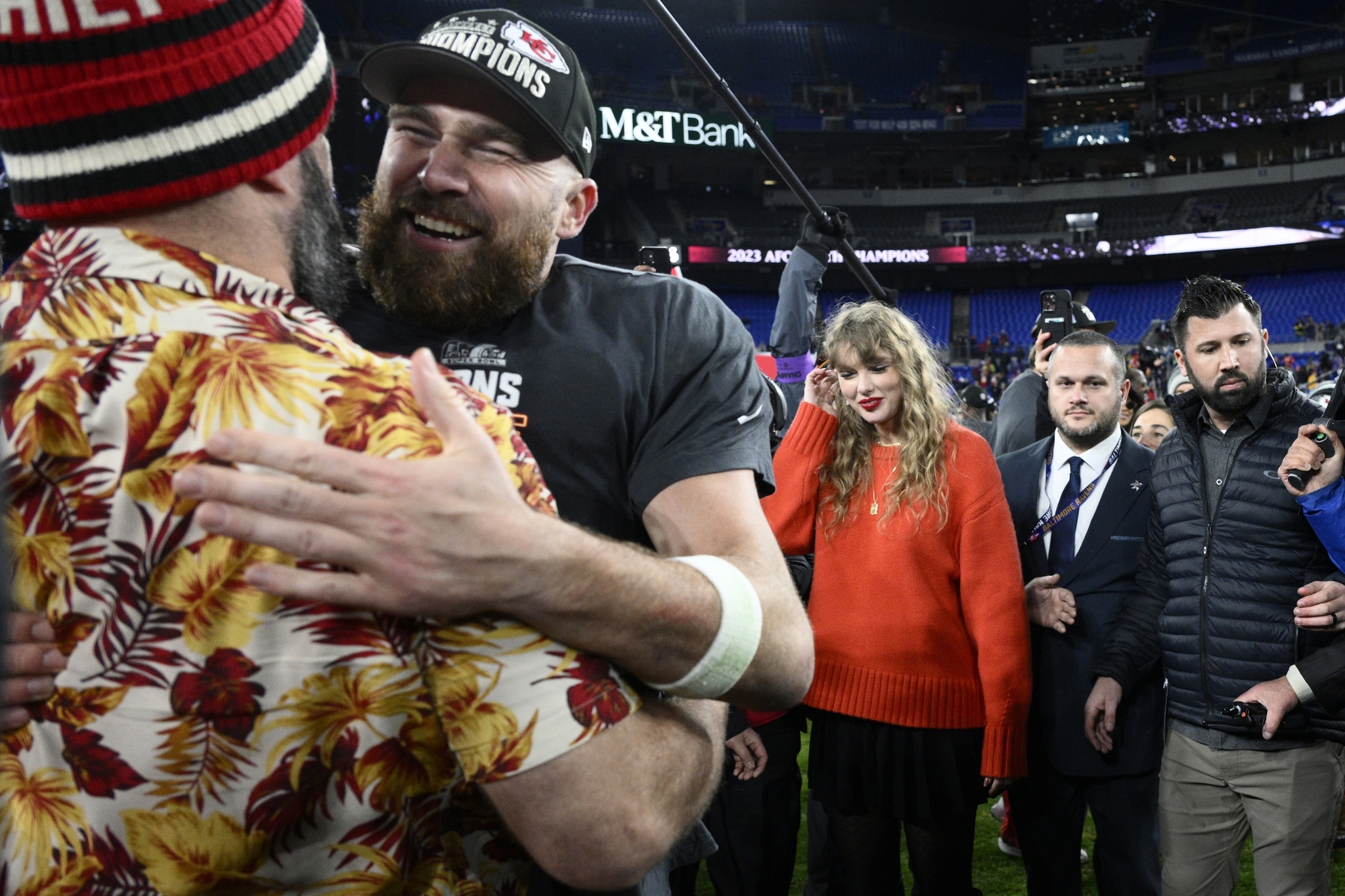 Jason Kelce embraces his brother Kansas City Chiefs tight end Travis Kelce as Taylor Swift stands at right