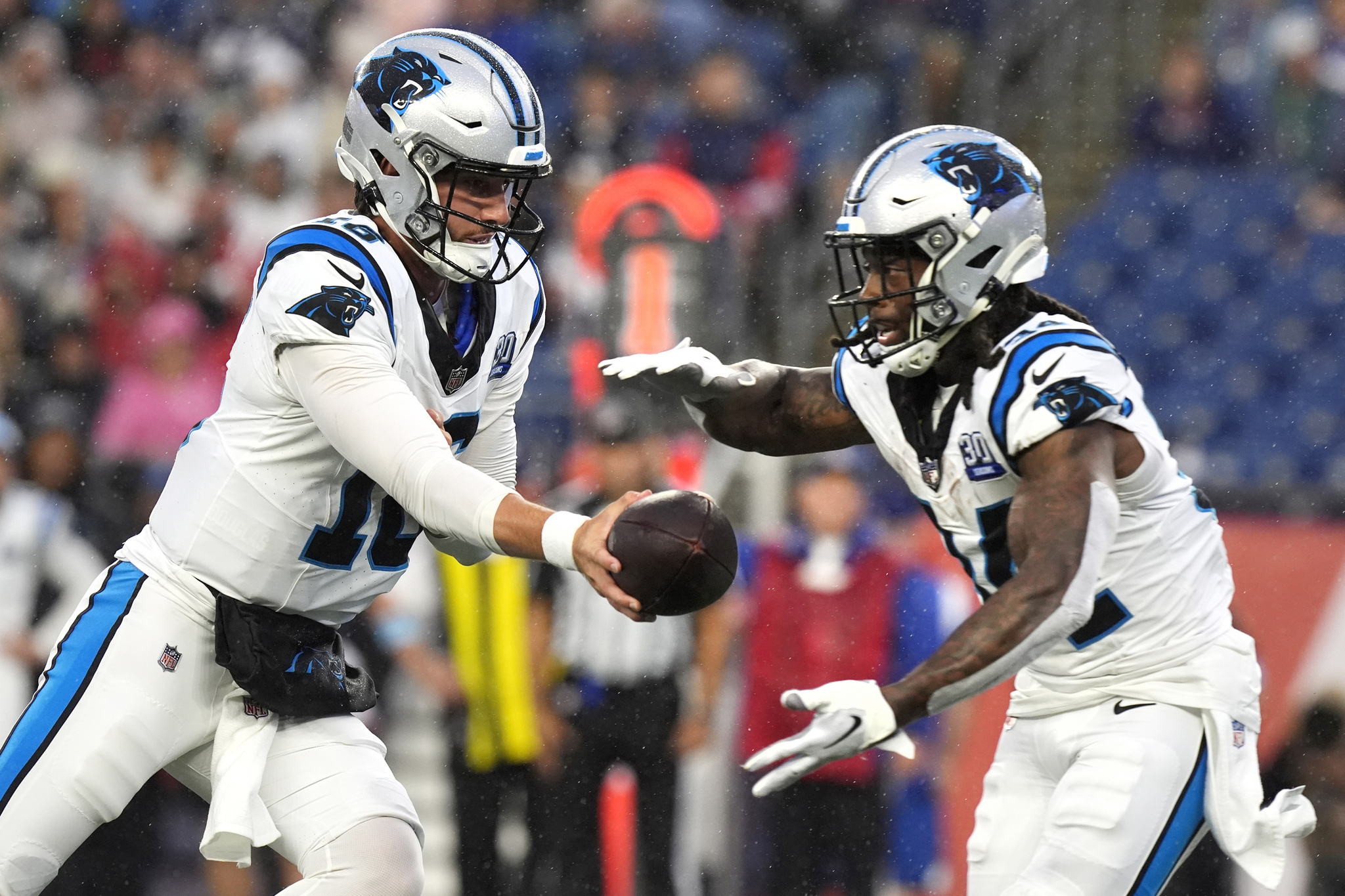 Carolina Panthers quarterback Jack Plummer, left, hands off to running back Mike Boone