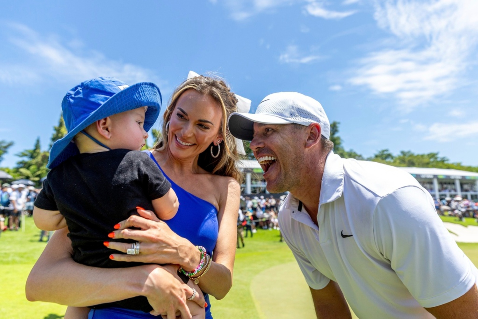 Brooks Koepka celebrates after his win with wife Jena Sims and son Crew in Singapore