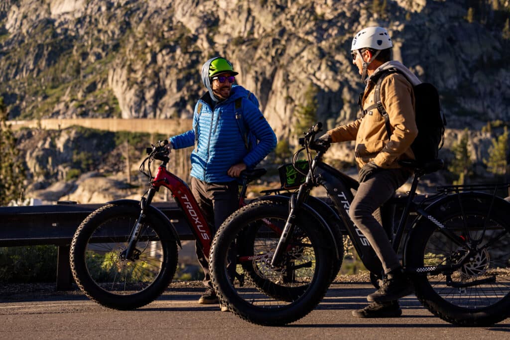 Two men riding on a two Troxus eBikes on a mountain road