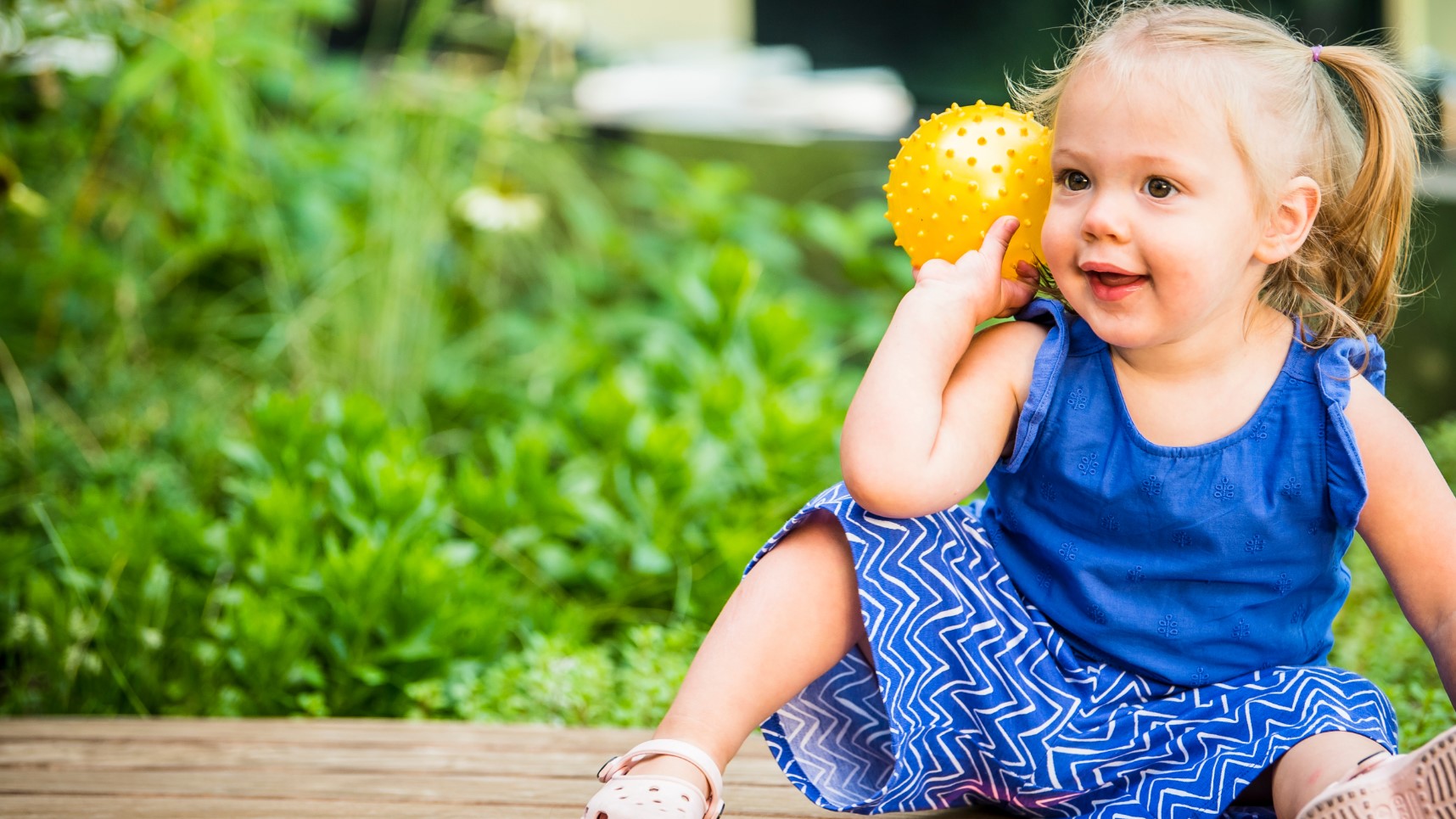 toddler holding yellow ball