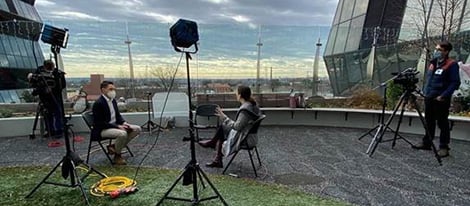 Camera crew doing an interview on outdoor balcony