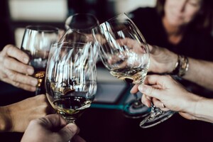 photo: several wine glasses raised together in a toast