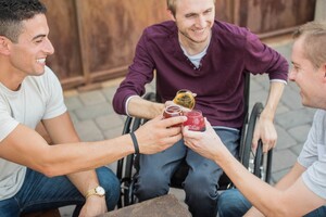 three men laughing, smiling, and having drinks together