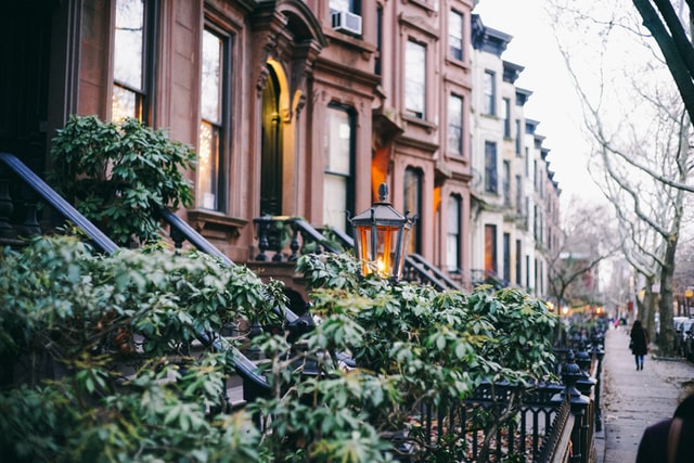 photo: receeding perspective shot of brownstone homes on a street with trees