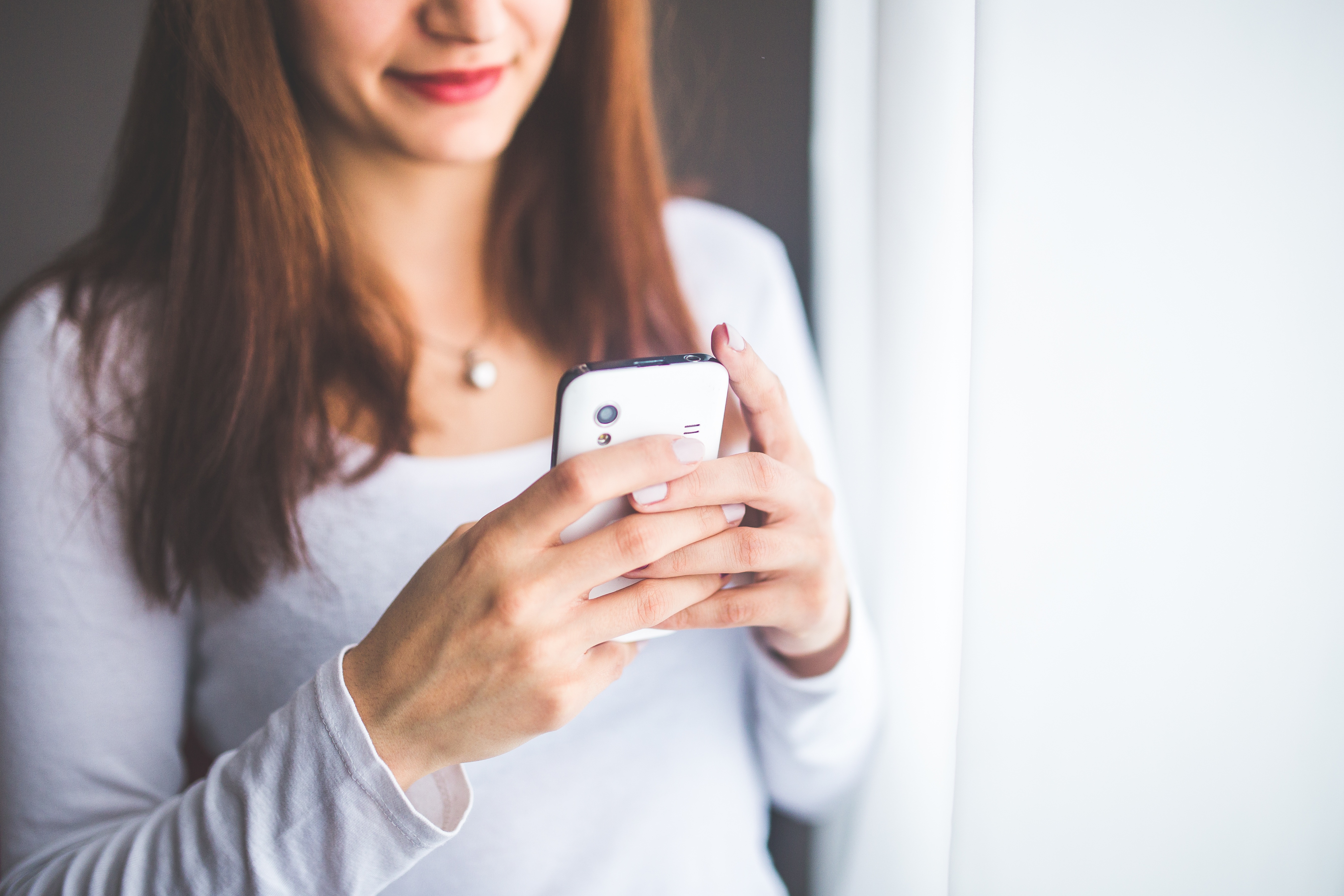 woman smiling looking at her phone