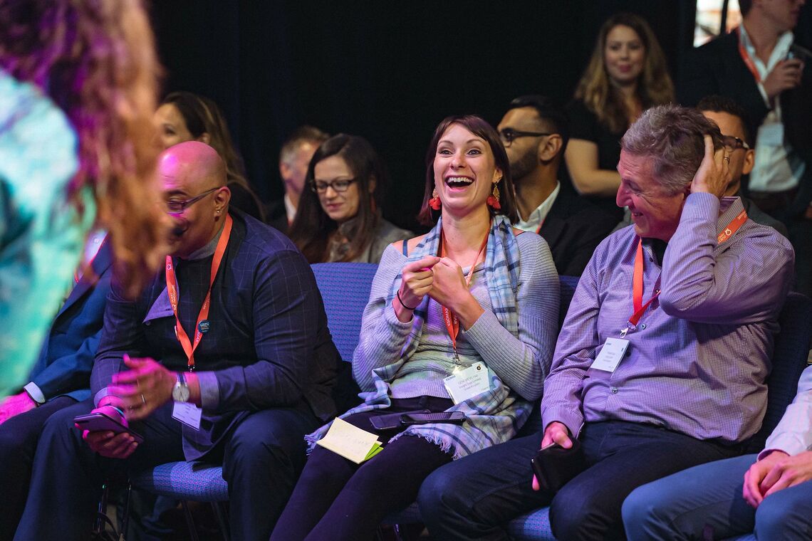 Woman laughing at a conference presentation