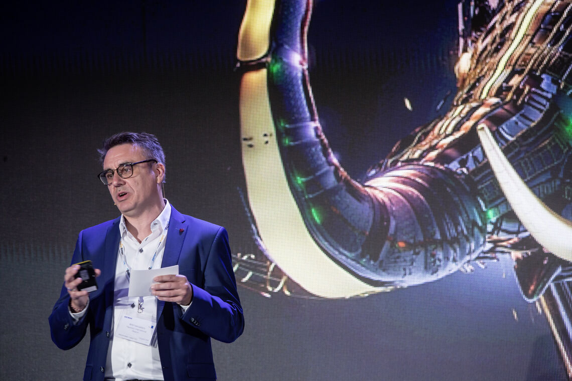 Wim Hamaekers speaking in front of an image of a futuristic metallic elephant