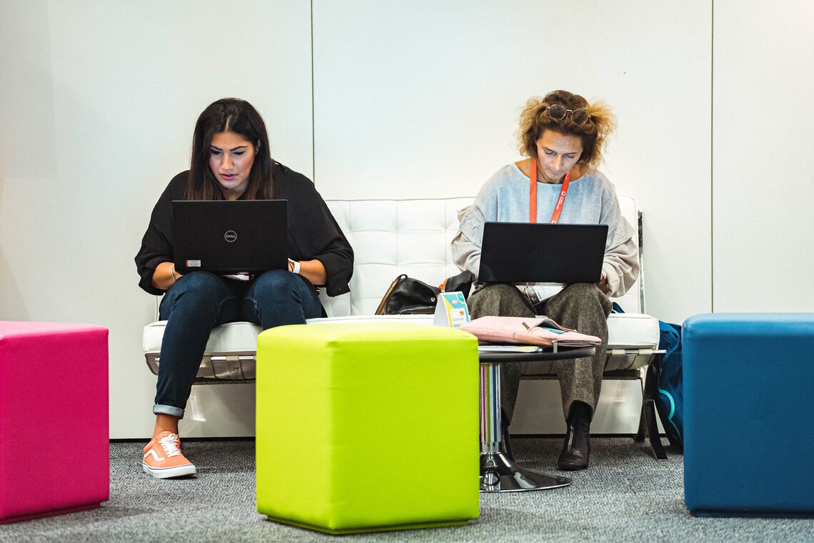 Two attendees focussed on their laptop screens