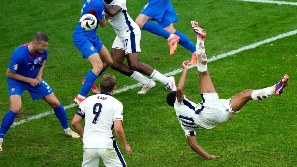 England's Jude Bellingham, right, scores his side's first goal with an overhead kick during a round of sixteen match between England and Slovakia at the Euro 2024 soccer tournament in Gelsenkirchen, Germany, Sunday, June 30, 2024.