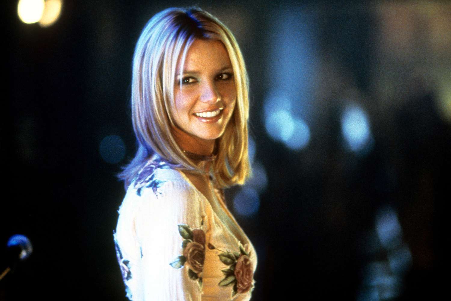 Britney Spears smiling as she looks back in a scene from the film Crossroads 2002.