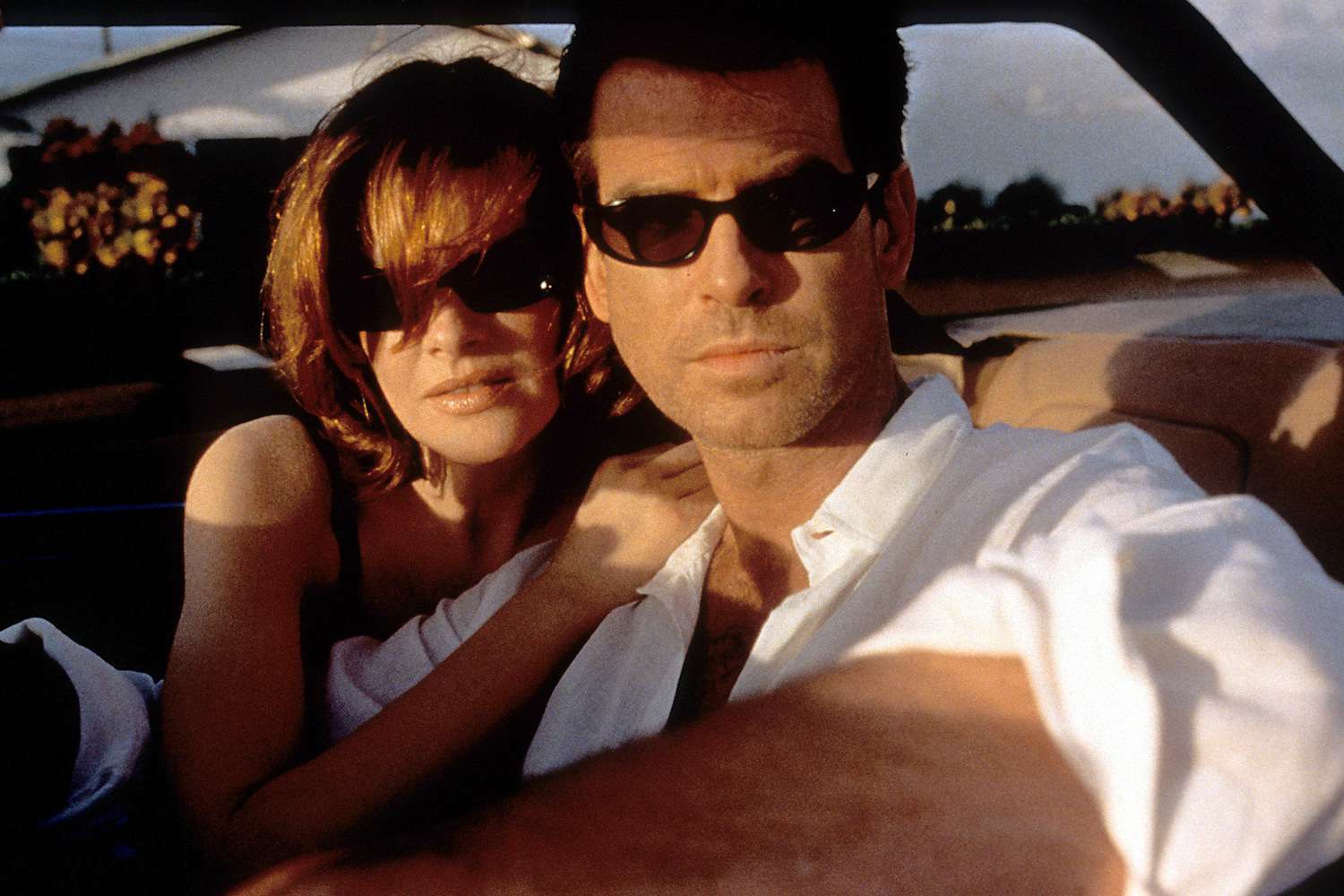 Pierce Brosnan and Rene Russo sitting in a car together in a scene from the film 'The Thomas Crown Affair', 1999. (Photo by Metro-Goldwyn-Mayer/Getty Images)