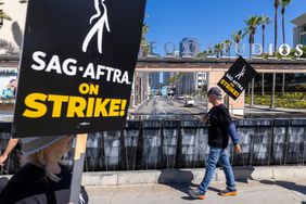 Striking SAG-AFTRA members walk a picket line in Los Angeles