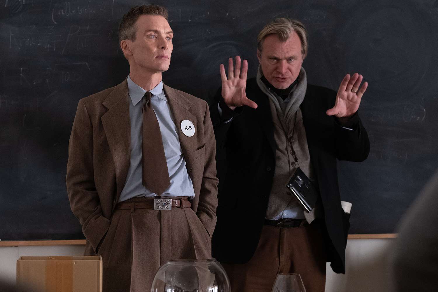 L to R: Cillian Murphy (as J. Robert Oppenheimer) and writer, director, and producer Christopher Nolan on the set of OPPENHEIMER