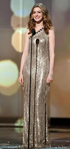 Hathaway kept things swingy in a silver beaded tassel dress by Oscar de la Renta, and complemented the glittery look in Tiffany jewels and gold