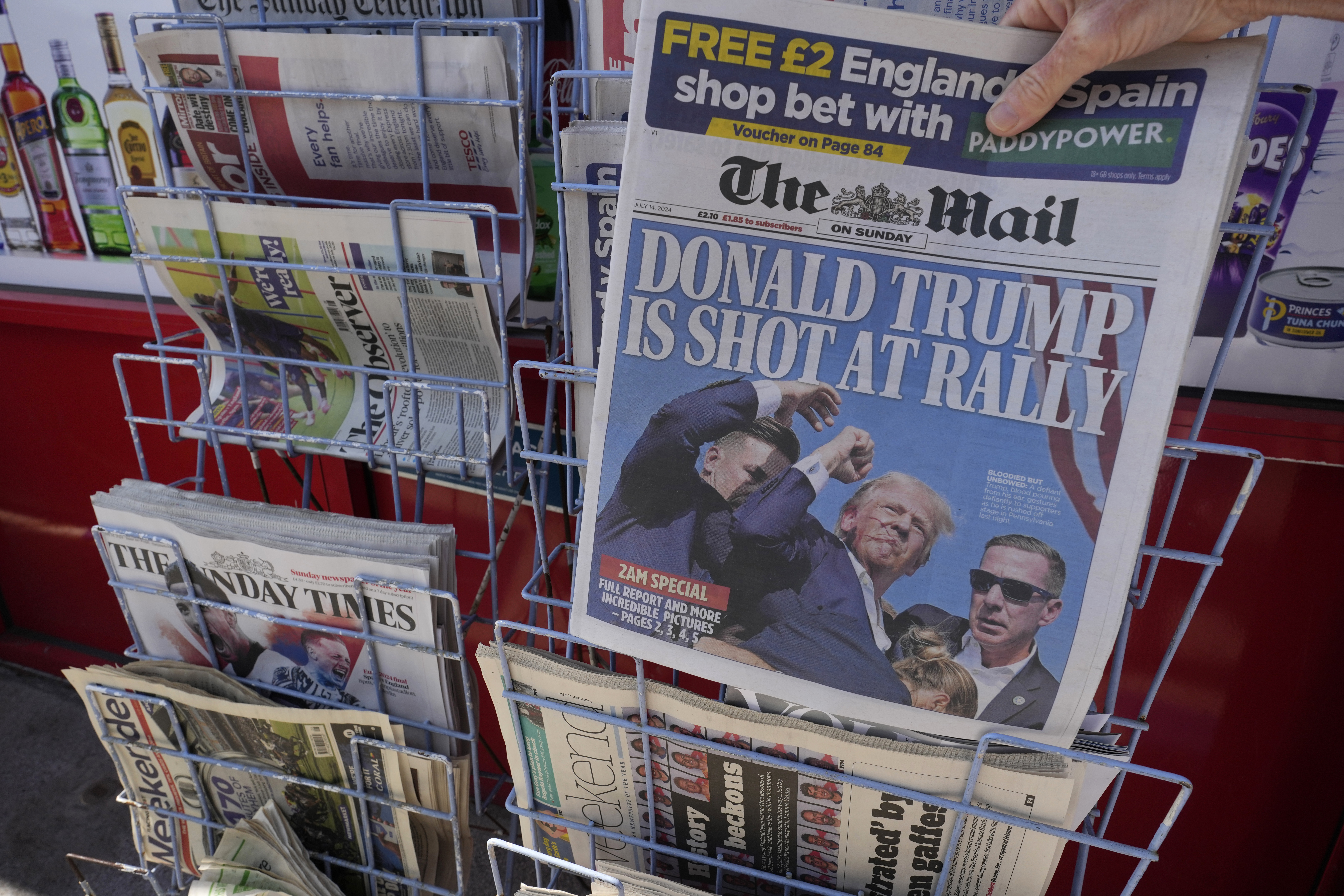 A woman buys a copy of the British Mail on Sunday in London.