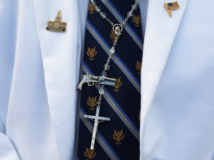 An evangelical Christian wears a rosary and a pin of a gun