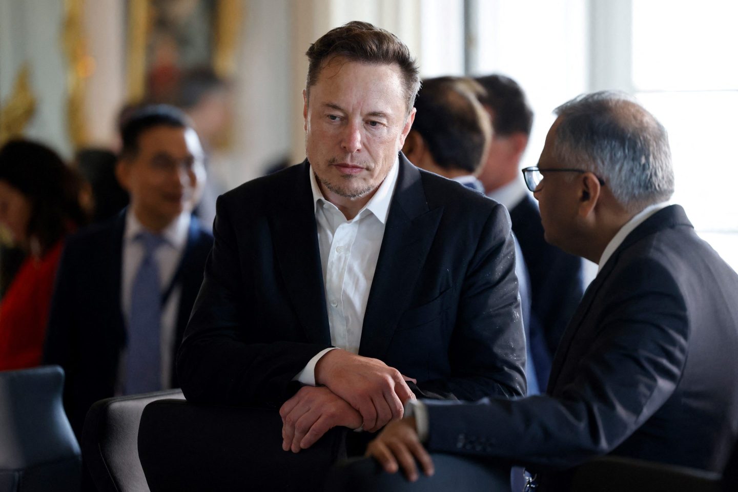 Electric car maker Tesla CEO Elon Musk looks on among other CEOs before a roundtable during the 6th edition of the &#8220;Choose France&#8221; Summit at the Chateau de Versailles, outside Paris on May 15, 2023. Since 2018, the Choose France Summit seeks to promote France&#8217;s economic attractiveness and encourage international investment across the country and brings together hundreds of leaders from the largest multinational corporations. (Photo by Ludovic MARIN / POOL / AFP) (Photo by LUDOVIC MARIN/POOL/AFP via Getty Images)