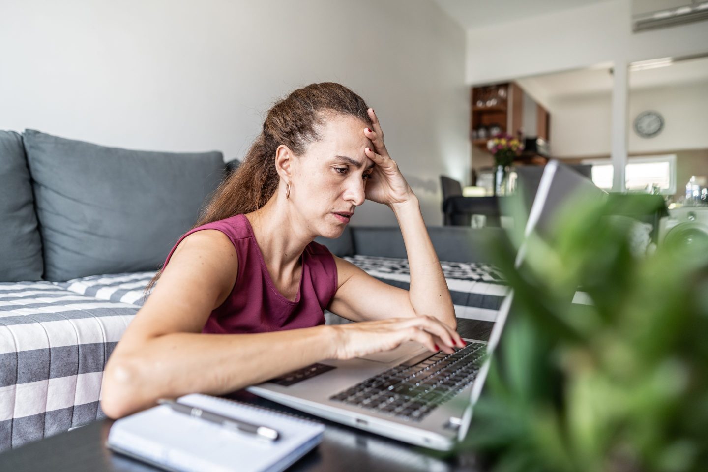 Worried woman using laptop at home