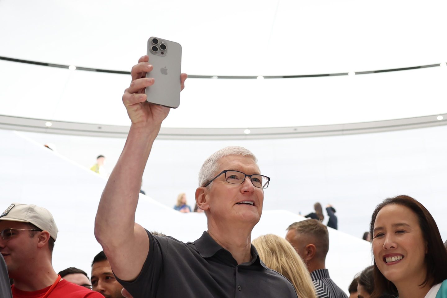 Tim Cook holds up iPhone