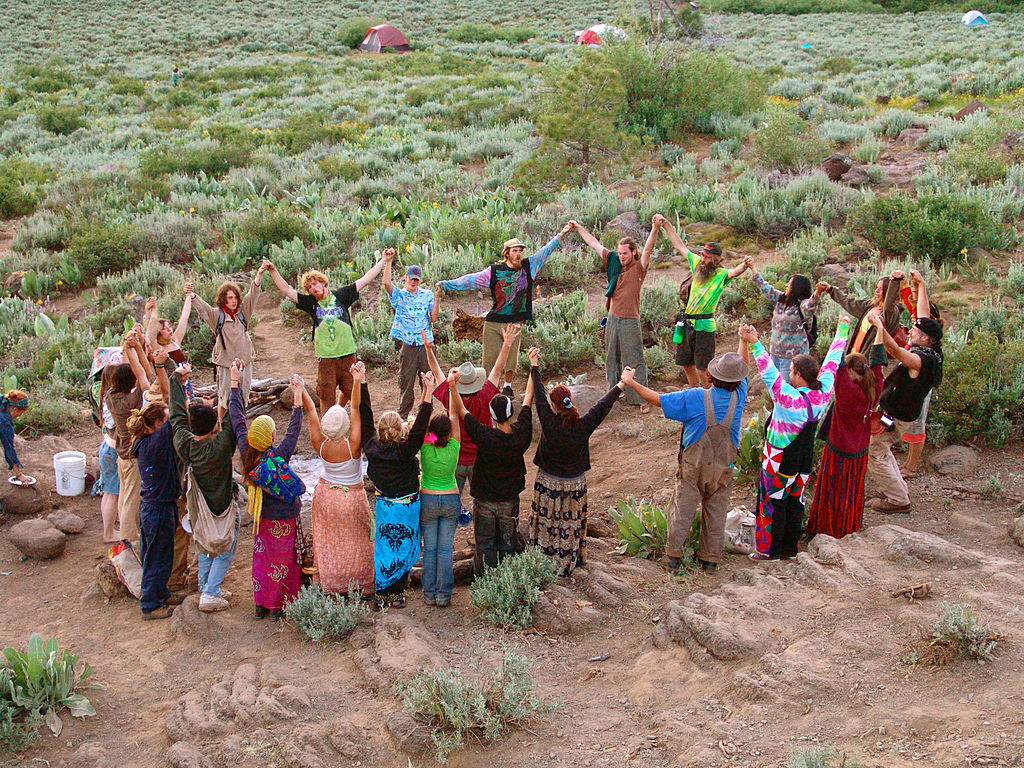 Members of the Rainbow Family Gathering in a circle holding hands