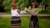 Women wearing traditional Romanian blouses known as ia or ie (pronounced "ee-yeh") use mobile phones to check their outfits during an event celebrating rural national costumes in Bucharest last month. 