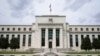 FILE - An American flag flies over the Federal Reserve building in Washington, May 4, 2021.