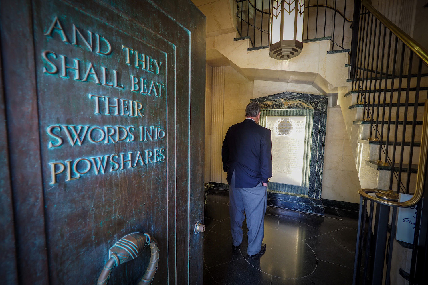 Bill Henry reading the plaque commemorating the NC State alumni who died while serving in the U.S. military during World War I.