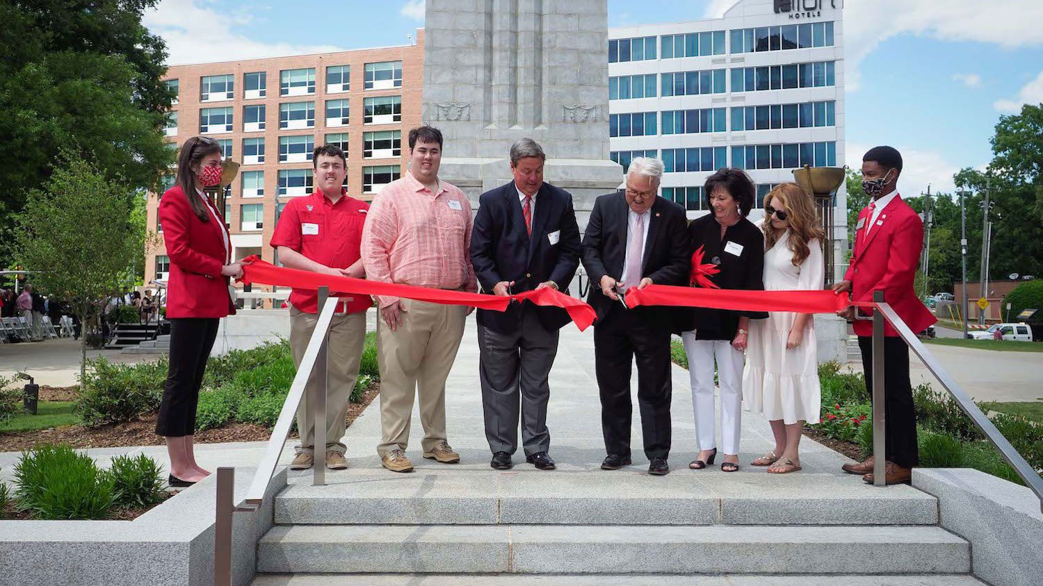 Chancellor Randy Woodson and the Henry family cutting the ribbon dedicating the Henry Square and reopening the Memorial Belltower.