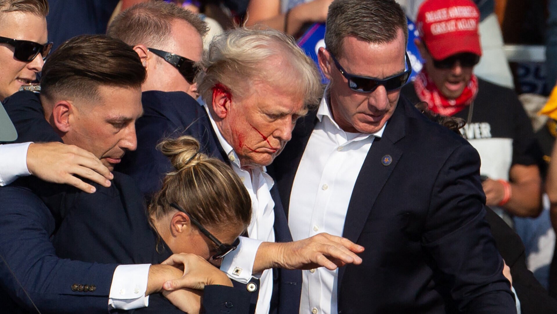 Donald Trump is seen with blood on his face surrounded by secret service agents as he is taken off the stage at a campaign event at Butler Farm Show Inc. in Butler, Pennsylvania, on July 13, 2024.