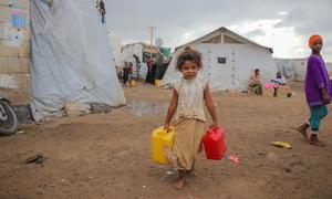 Uma criança busca água potável em um acampamento para deslocados em Dar Saad, no Iêmen