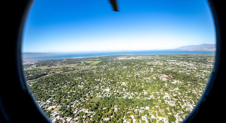 Um helicóptero sobrevoa uma área urbana no Haiti