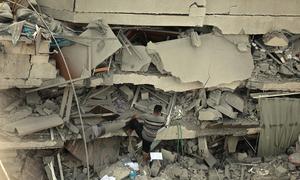 Um homem escala edifício destruído em Gaza