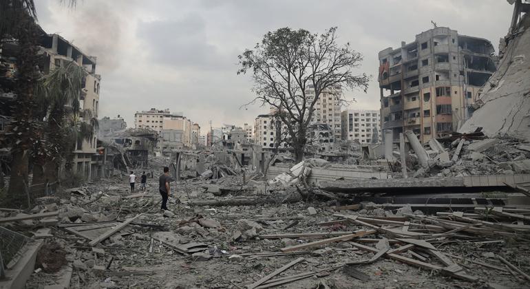 No meio da violência implacável, famílias fogem das suas casas destruídas no bairro de Tal al-Hawa, procurando refúgio no sul da Faixa de Gaza