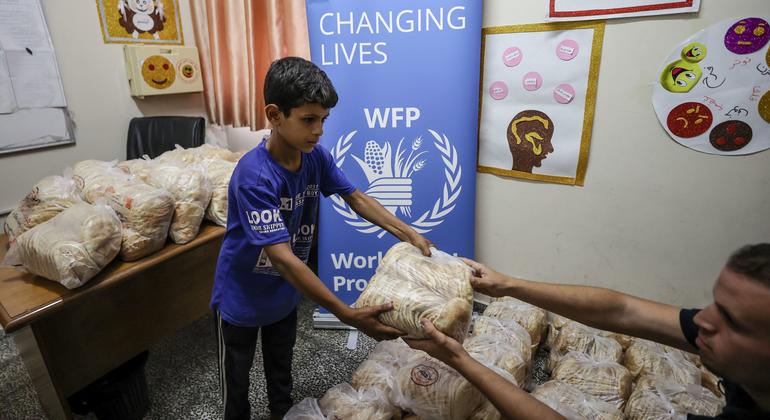 Um menino recebe pão do PMA num abrigo em Gaza