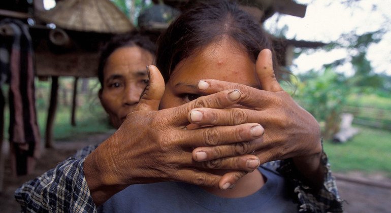 Una madre cubre el rostro de su hija, víctima de la trata a los dieciséis años, para proteger su identidad.