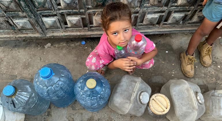 A child waits to fill water containers in Gaza.