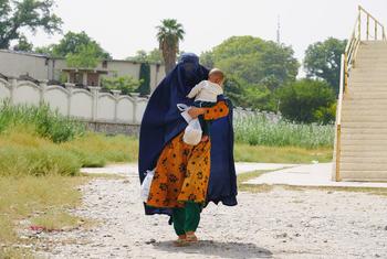 A woman walks with her child in her arms in Jalalabad, Afghanistan.