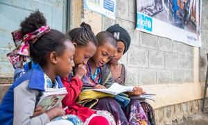 Meninas sentam juntas e estudam do lado de fora de uma escola apoiada pelo UNICEF no centro de Tigray, na Etiópia