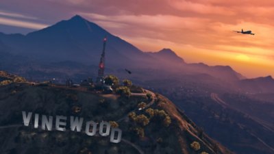 Grand Theft Auto V - Istantanea della schermata del sole che tramonta tra le colline con la scritta "Vinewood" a grandi lettere