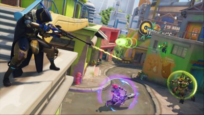 Overwatch 2 screenshot of character pointing weapon from atop a building ledge.