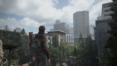 The Last of Us Part II Remastered – Screenshot, der Ellie über Seattle blickend zeigt.