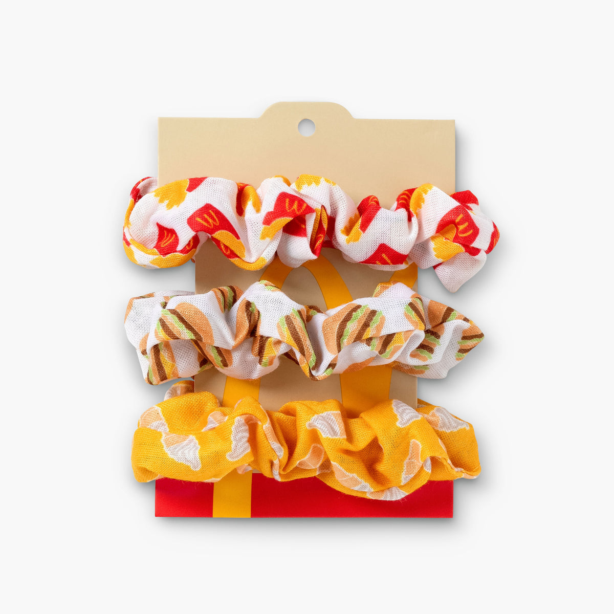 3 Pack of scrunchies on a backer. Fry Scrunchie, Big Mac Scrunchie, Yellow Ice Cream Scrunchie.