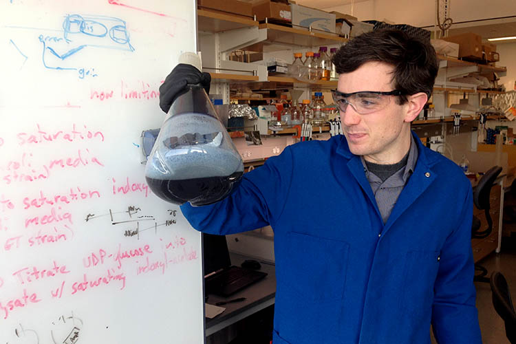 Bioengineering graduate student Zach Russ holding a beaker