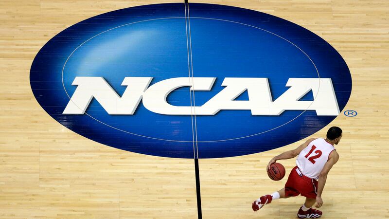 FILE - Wisconsin's Traevon Jackson dribbles past the NCAA logo during practice at the NCAA...