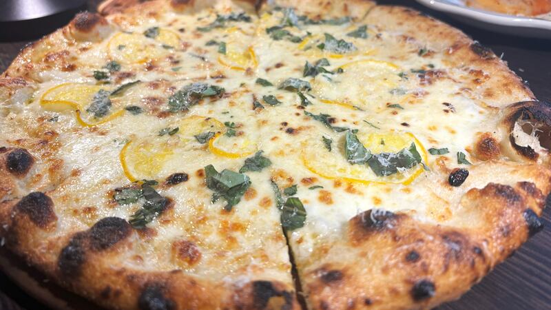 The lemon pizza features mozzarella, garlic creme sauce & caciocavallo cheese