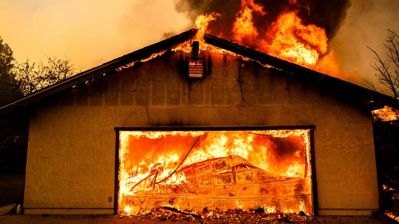 Flames consume a garage as the Thompson Fire burns in Oroville, Calif., Tuesday, July 2, 2024....