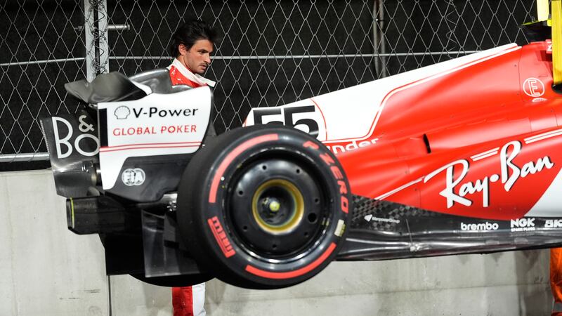 Ferrari driver Carlos Sainz, of Spain, looks at his car after he stopped on the track during...