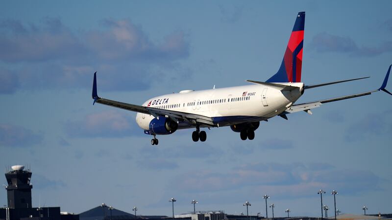 FILE - A Delta Airlines flight from Atlanta makes its landing approach onto...